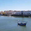 Boot auf dem Wasser schippert vor einer portugiesischen Stadt umher