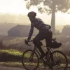 Fahrradfahrer fährt bei Sonnenaufgang über die Straße