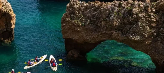 Menschen fahren in Kanus über die Algarve