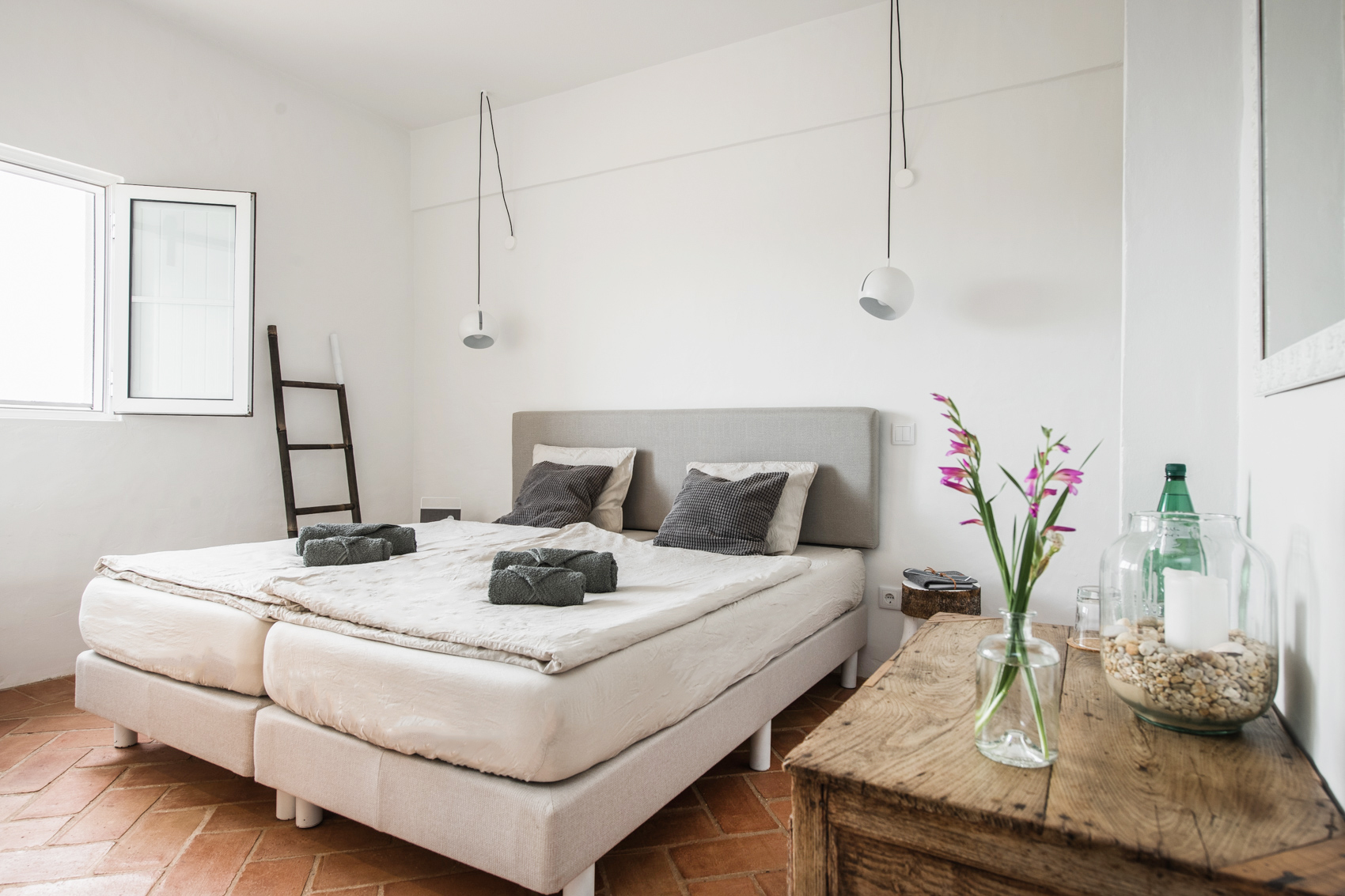 Quarto moderno e minimalista na CASA KALU com luz natural e mobiliário elegante no Algarve