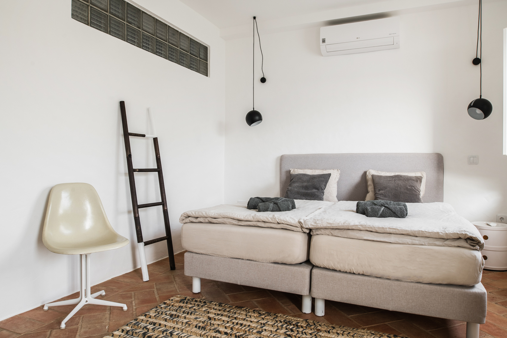 Quarto moderno e minimalista na CASA KALU com luz natural e mobiliário elegante no Algarve
